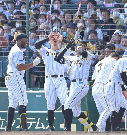 　２回、先制ソロを放ち、佐藤輝（左から２人目）と共にポーズを決める糸井（同３人目）＝撮影・高部洋祐