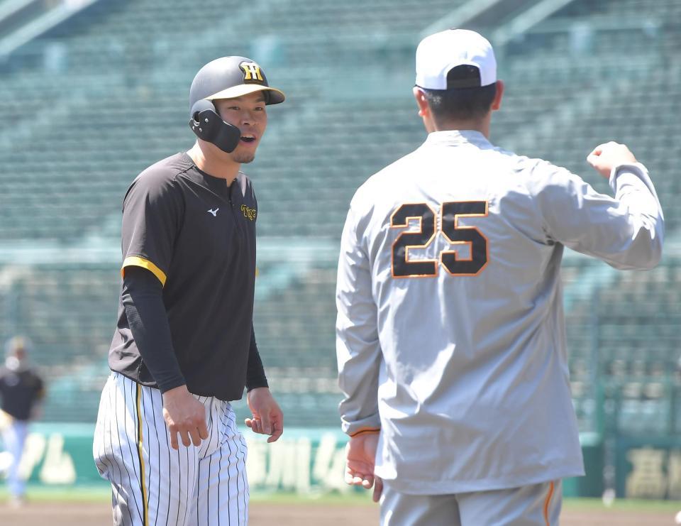 　試合前、岡本和（右）と言葉を交わす佐藤輝（撮影・高部洋祐）