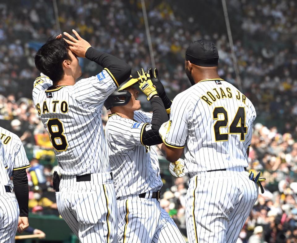 　２回、先制ソロを放ち生還した糸井（中央）は佐藤輝とポーズを決める（撮影・山口登）