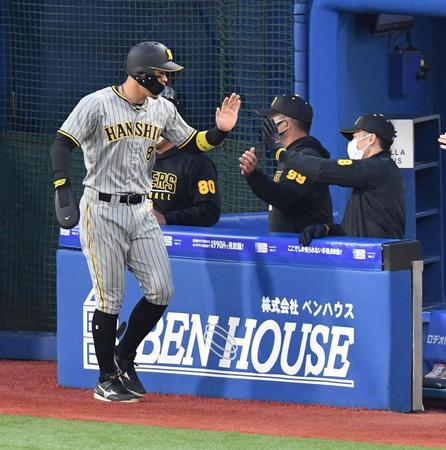 　１回、糸井の先制打で生還し、矢野監督（右）に祝福される佐藤輝（撮影・西岡正）