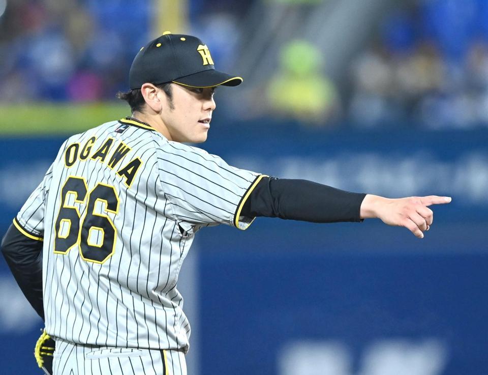 　２回、牧の二盗を阻止した梅野を指さす小川（撮影・飯室逸平）