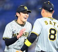 　７回、ピンチをしのぎ、笑顔で佐藤輝とタッチを交わす小川