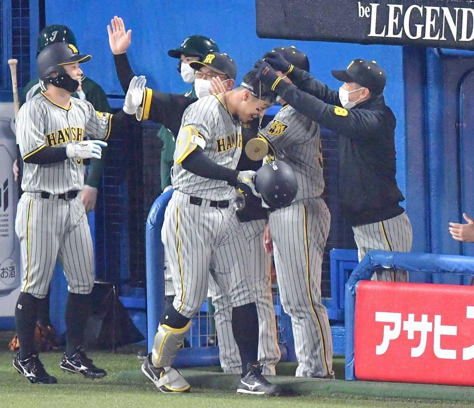 　１回、右越えに２ランを放ち矢野監督からメダルをかけられる佐藤輝（撮影・佐々木彰尚）