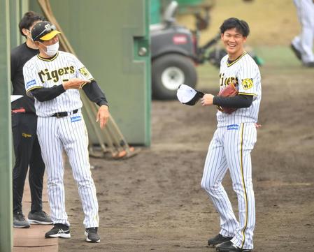 　シート打撃後、平田二軍監督（左）から声をかけられ笑顔を見せる及川（撮影・吉澤敬太）