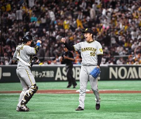　２試合連続完投で３勝目を挙げ、梅野（左）とタッチする青柳（撮影・佐藤厚）