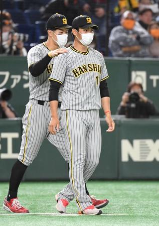 　今季初登板初勝利を挙げ、佐藤輝（左）から肩をもまれる西純（撮影・佐藤厚）