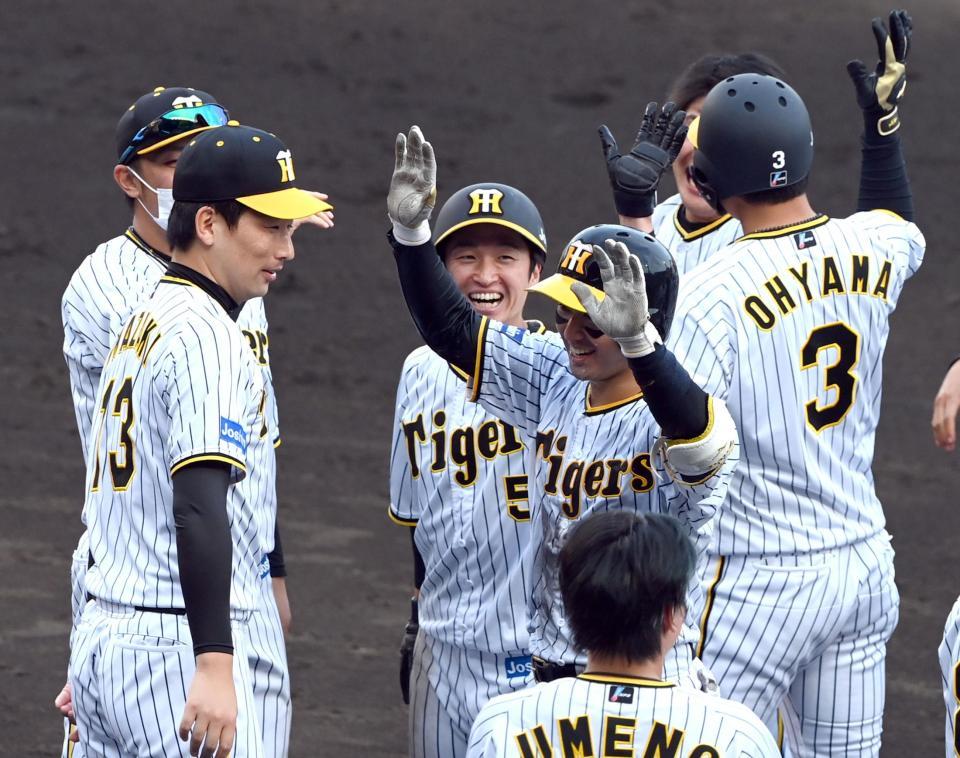 　９回、近本（中央）は、山本（中央右）の押し出し四球で生還しサヨナラ勝利で笑顔を見せる（撮影・山口登）