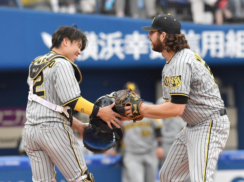 　３回、関根の捕邪飛を捕球した梅野（左）にマスクを手渡すウィルカーソン（撮影・西岡正）