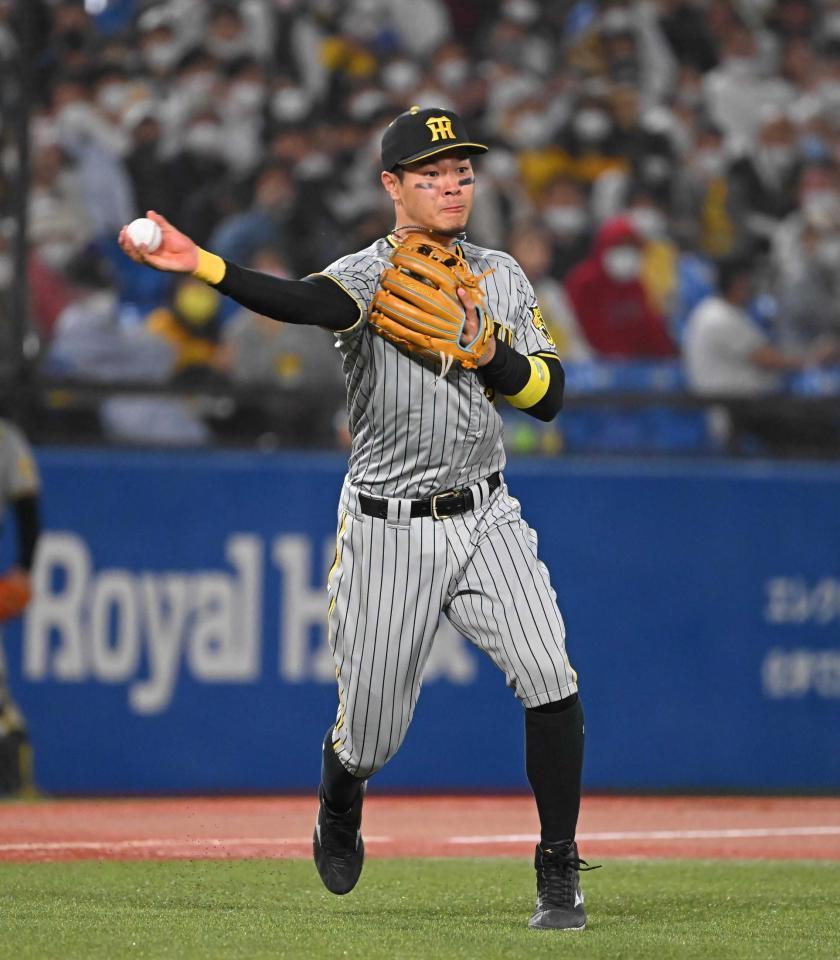 　７回、一塁に悪送球する佐藤輝