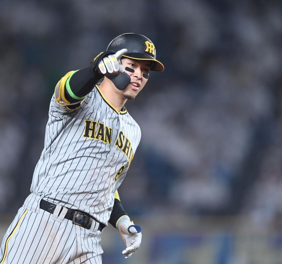 ９回、先制ソロを放った佐藤輝は右手を挙げながら三塁へ走る（撮影・田中太一）