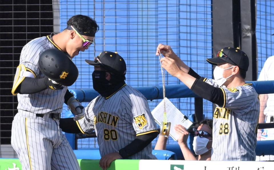 　８回、矢野監督（右）からトラメダルをかけてもらう佐藤輝（撮影・堀内翔）