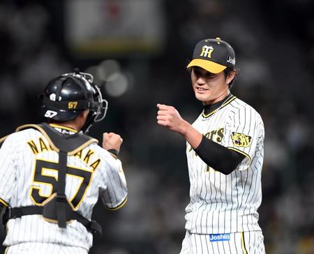 　９回、無死点に抑えベンチに戻る藤浪（右）は長坂とグータッチ（撮影・山口登）