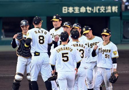 日本ハムに勝利し、マウンドでナインとタッチする阪神・坂本（左）＝甲子園（撮影・山口登）