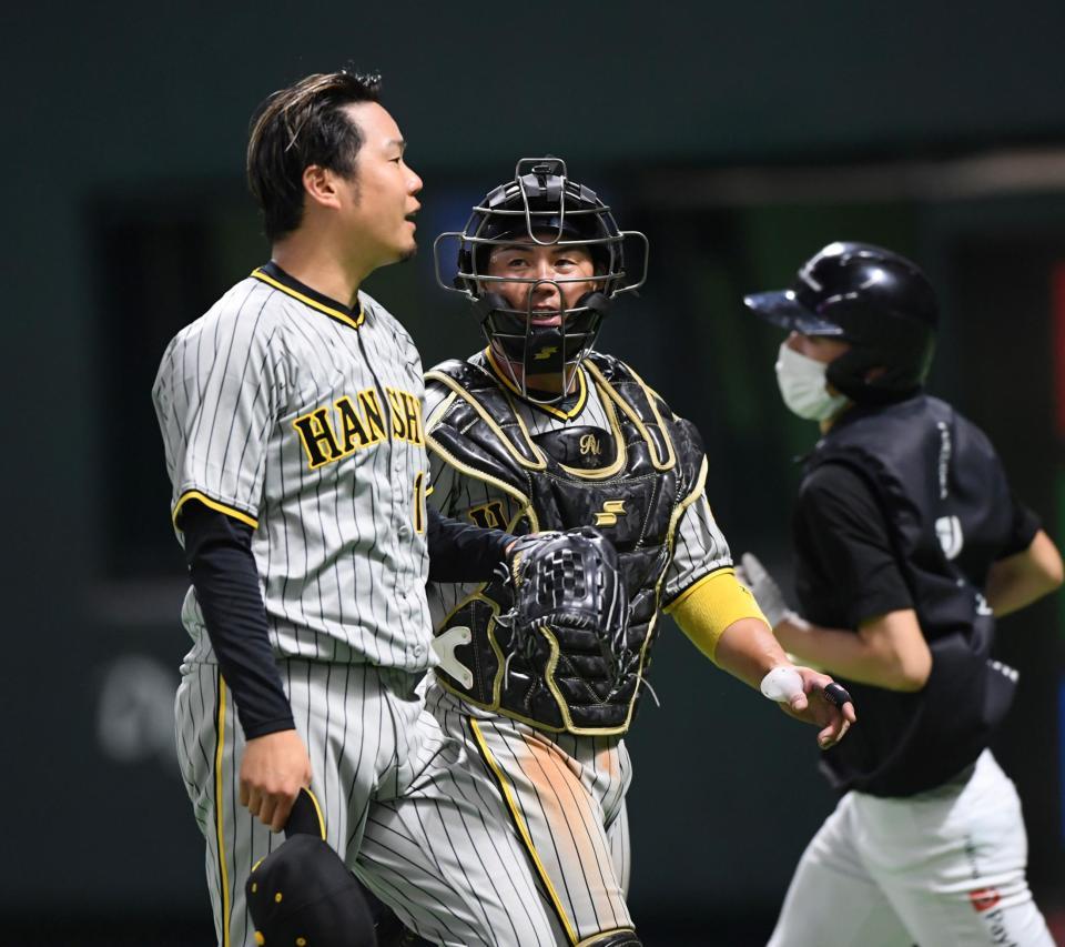 ３回、ピンチを脱しベンチへ引き揚げる西勇（左）と梅野