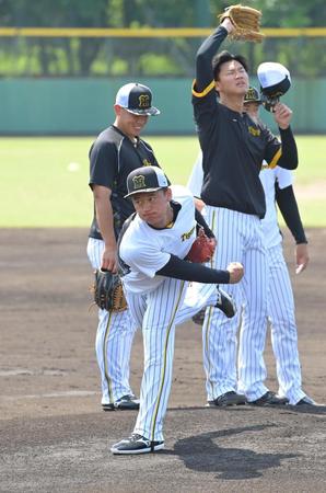 登板に備え調整する森木（手前）＝撮影・高部洋祐