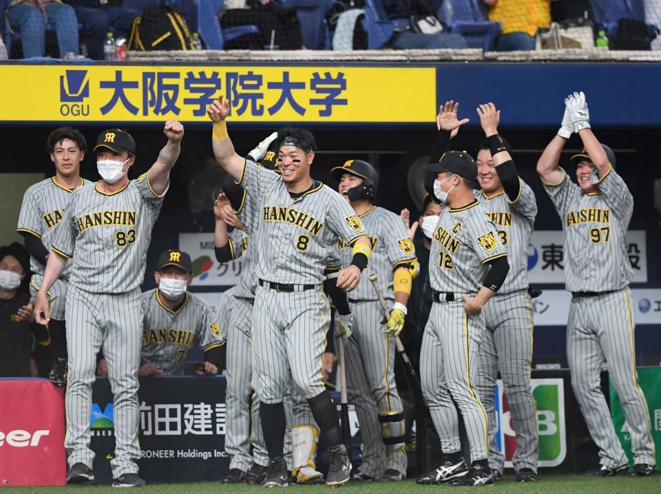 　１１回、熊谷が勝ち越しヘッドスライディングを決めると佐藤輝（中央）らはベンチから飛び出して大喜び（撮影・田中太一）