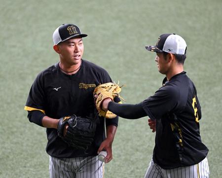 　１軍に合流した桐敷（左）は、キャッチボールを終え岡留とグラブタッチする（撮影・山口登）