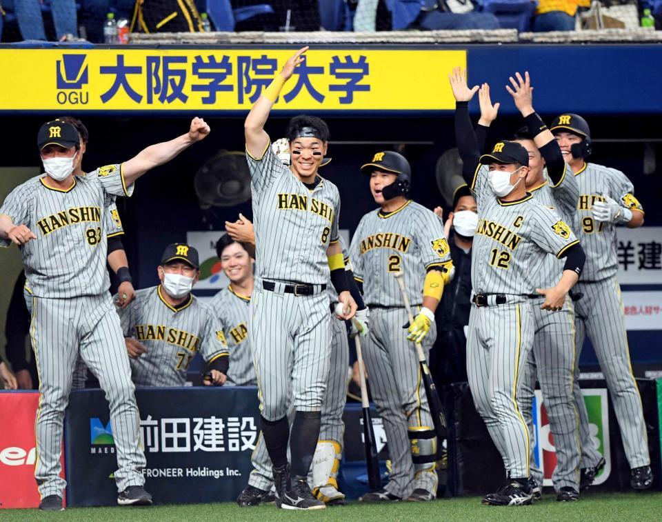 　延長１１回、熊谷が勝ち越しヘッドスライディングを決め、大喜びでベンチから飛び出す佐藤輝（中央）ら阪神ナイン（撮影・田中太一）