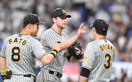 　完投勝利を飾り、佐藤輝（８）、大山（３）らと勝利のハイタッチを交わすガンケル（撮影・飯室逸平）