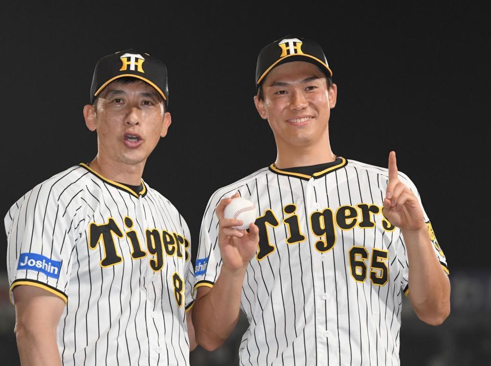 　矢野監督（左）から祝福され、ウイニングボールを手に笑顔でポーズを決める湯浅（撮影・飯室逸平）