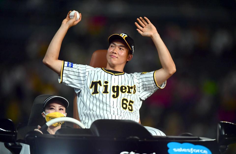 　プロ初勝利をした湯浅はウイニングボールを手にスタンドのファンに応える（撮影・山口登）