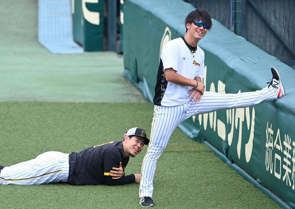 　ストレッチをしながら談笑する（右から）伊藤将（手前）と佐藤輝（撮影・田中太一）