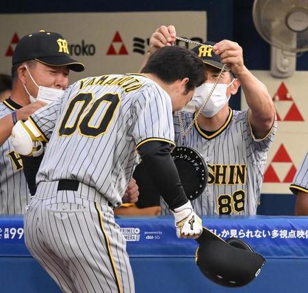 　２回、同点のソロを放った山本（手前）にトラメダルをかける矢野監督（撮影・堀内翔）