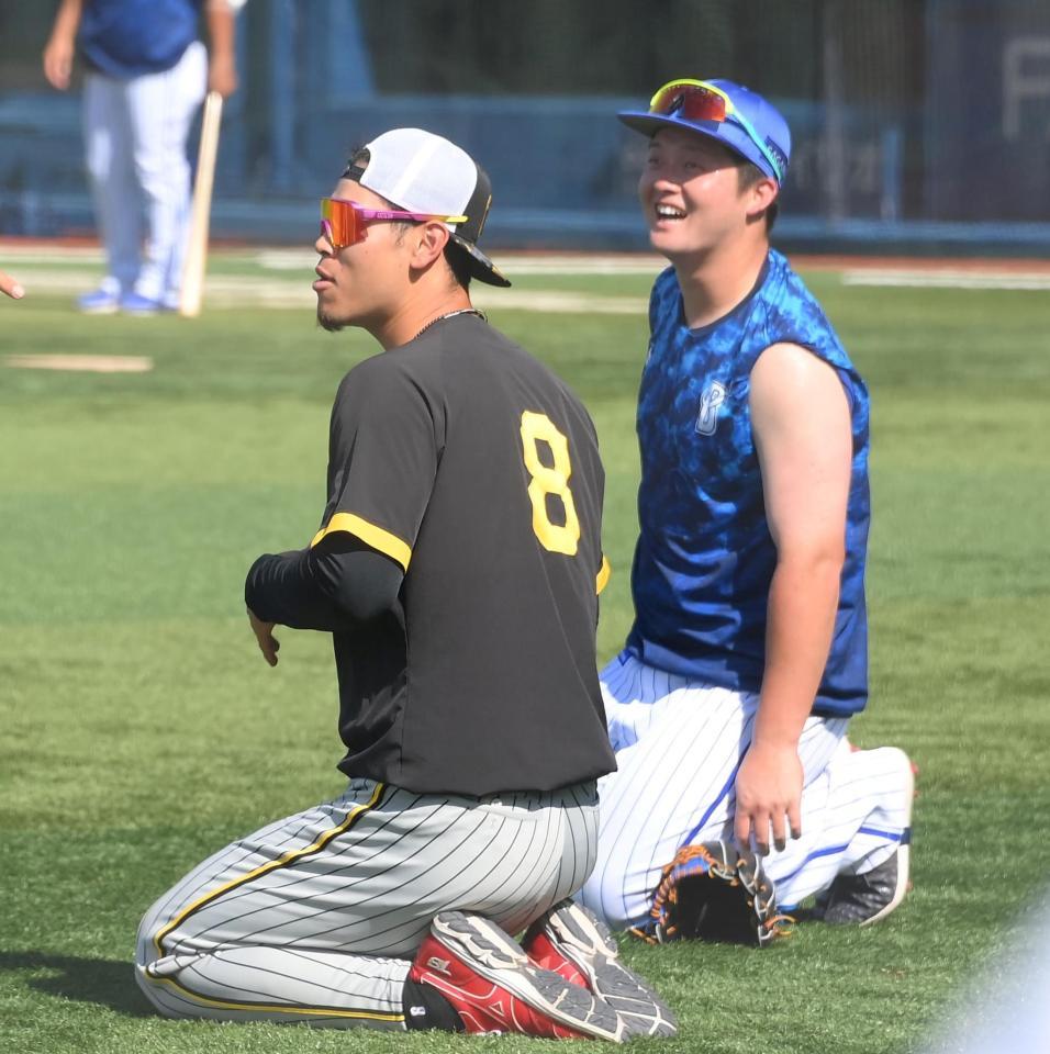 　練習中に談笑する佐藤輝と牧（右）＝撮影・堀内翔