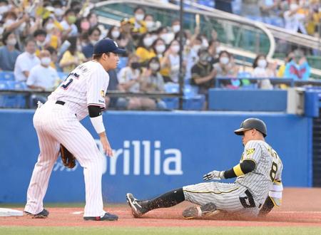 １回、先制の適時三塁打を放ちスライディングする阪神・佐藤輝。左はヤクルト・村上＝神宮（撮影・堀内翔）