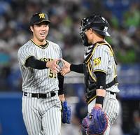 完封で９勝目を飾り、坂本（右）と握手を交わす阪神・青柳晃洋＝神宮（撮影・飯室逸平）