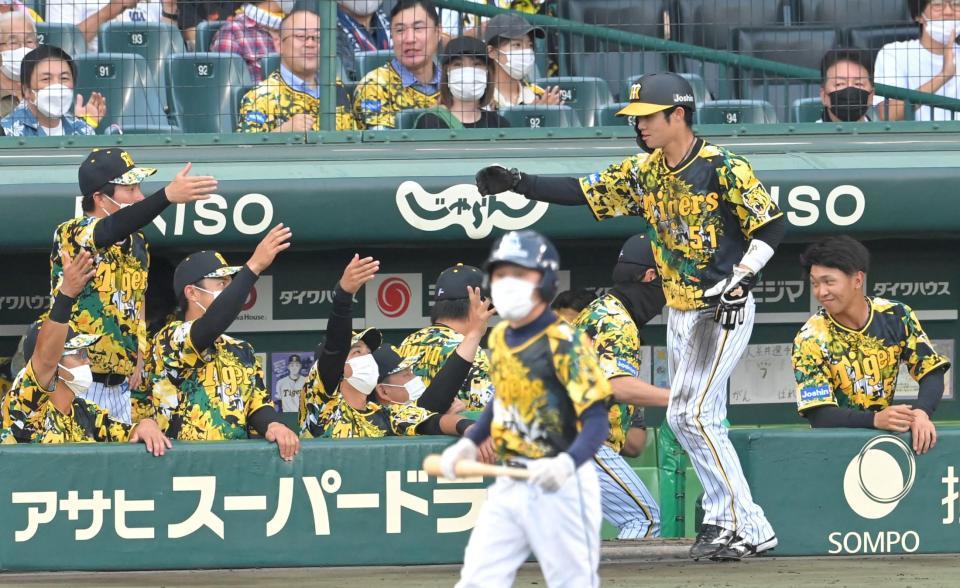 １回、近本の先制打で生還し、ナインとタッチを交わす中野（右から２人目）＝撮影・高部洋祐