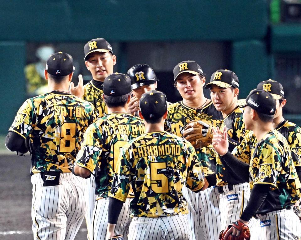 　中日に勝利しマウンドでタッチを交わす岩崎（左から２人目）、北條（中央）ら阪神ナイン（撮影・山口登）