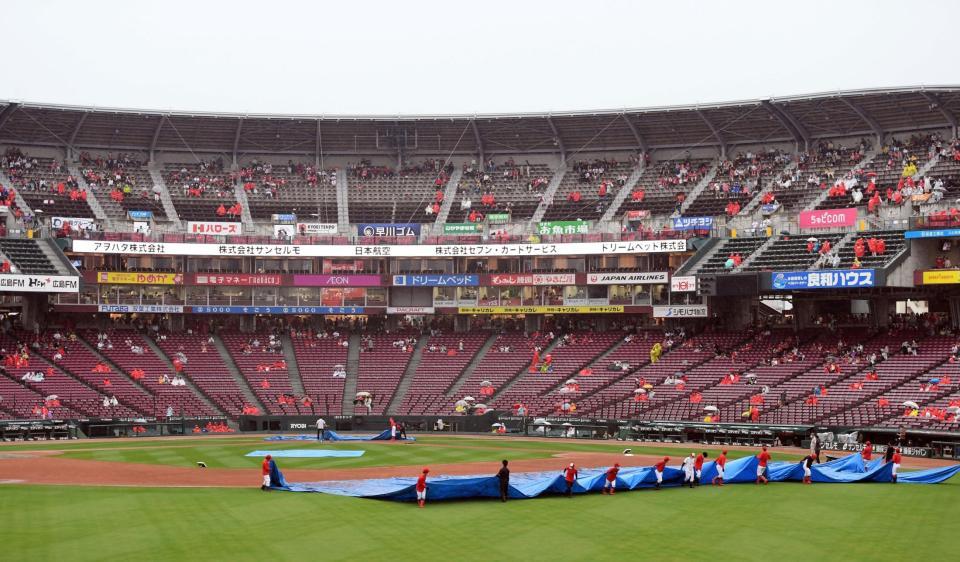 　試合に向けグラウンドに敷かれたシートはめくられたが、雨が強まり中止となったマツダスタジアム（撮影・山口登）
