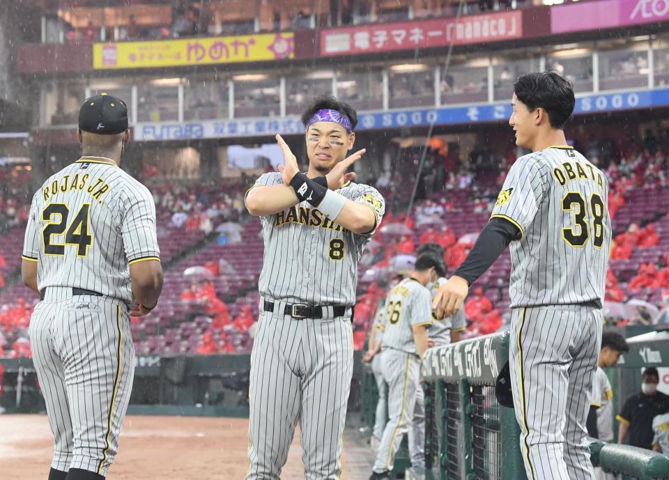 　国歌斉唱後、グラウンドへ向かって×印をする佐藤輝。この直後、中止となる（撮影・田中太一）