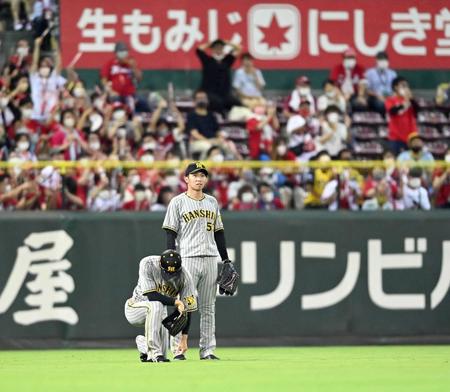 　７回、磯村の打球を捕れず、ピンチを広げた近本（左）は座り込んでうなだれる