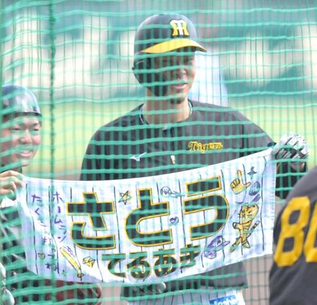 　打撃練習前、タオルを広げる佐藤輝（右）＝撮影・北村雅宏