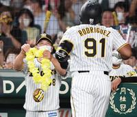 　４回、矢野監督は特製メダルを持ってロドリゲス（手前）を迎える（撮影・田中太一）