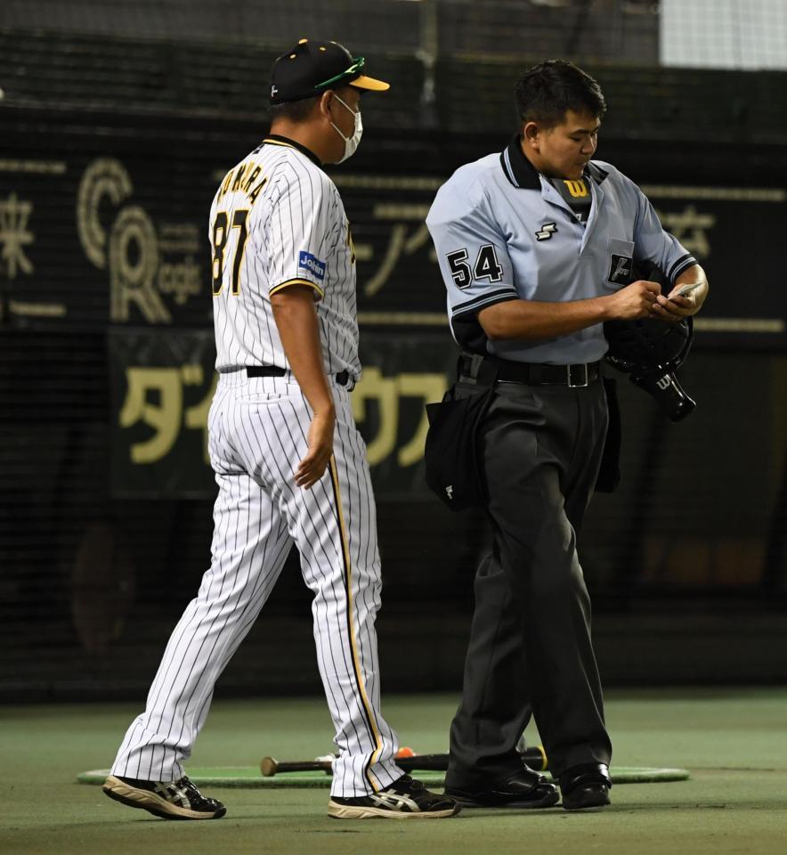 　選手交代を告げる野村２軍バッテリーコーチ（左）（撮影・石井剣太郎）