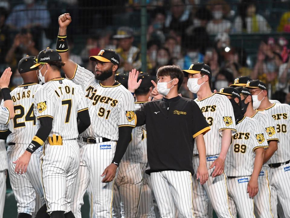 　開幕以来初めて貯金１とし、手を挙げてナインを迎えるロドリゲスと西勇（撮影・田中太一）