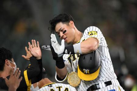 　５回、佐藤輝は左越えに本塁打を放ち、ベンチでナインに迎えられる