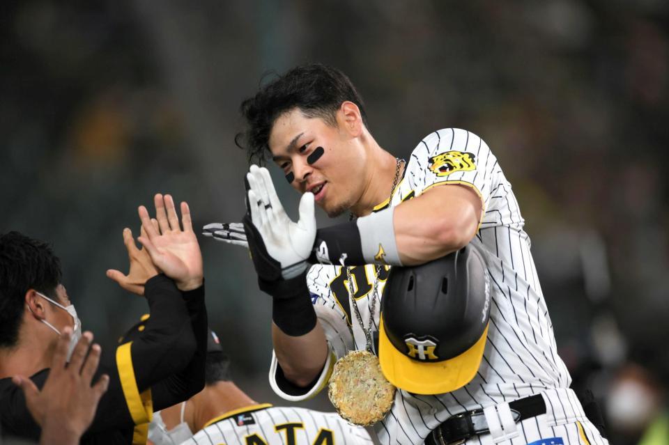 　５回、佐藤輝は左越えに本塁打を放ち、ベンチでナインに迎えられる