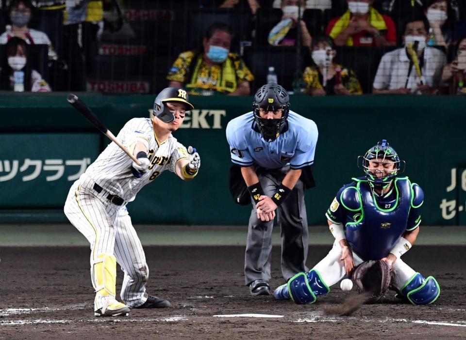 　５回、２死満塁の好機に佐藤輝は空振り三振に倒れる（捕手・中村）＝撮影・山口登