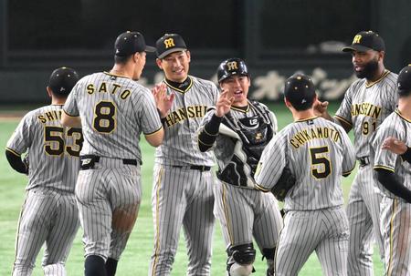 　巨人に勝利してタッチを交わす梅野ら阪神ナイン（撮影・堀内翔）