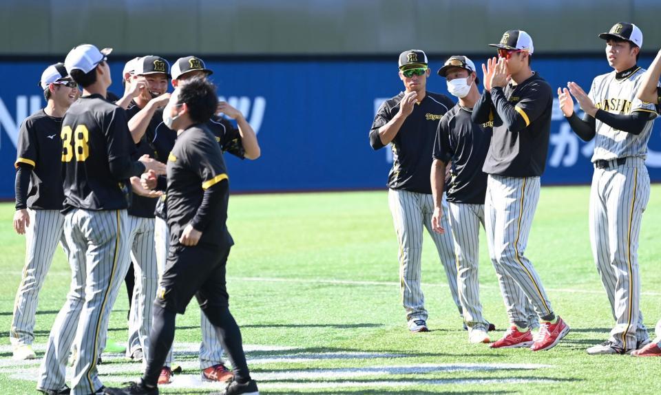 　チームに合流した小野寺（左から３人目）は佐藤輝（右から２人目）らナインから拍手され笑顔を見せる（撮影・田中太一）