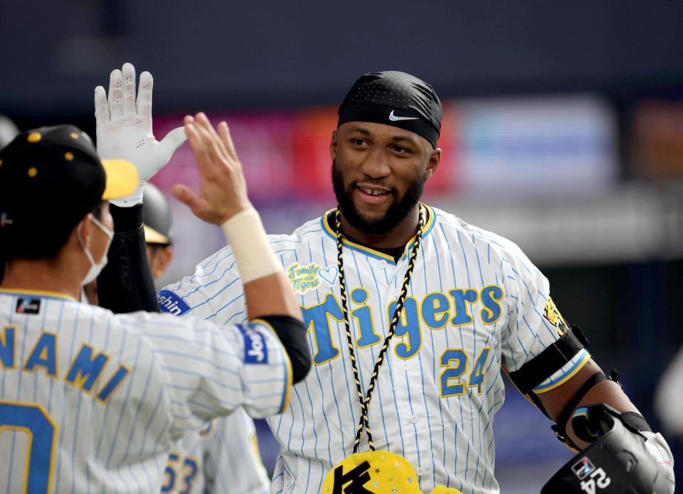 　５回、同点３ランを放ったロハスはナインとタッチを交わす（撮影・田中太一）