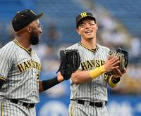 キャッチボールを終え、談笑する佐藤輝（右）とロハス（撮影・飯室逸平）