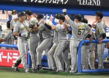 　４回、左越えにソロを放ち、ベンチ前でナインに出迎えられる原口（撮影・佐々木彰尚）