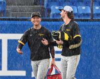　突然の豪雨の中、ケラー（右）と談笑する西純