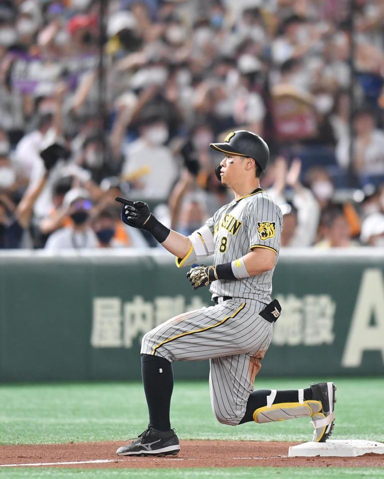 　８回、２点三塁打を放ち、ベンチへ向かってポーズを決める佐藤輝