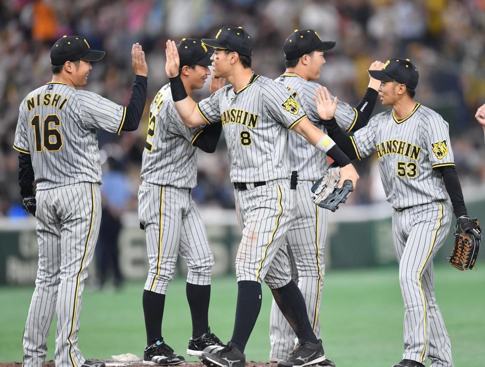 　巨人に勝利し、西勇（左）とタッチを交わす佐藤輝（中央）＝撮影・西岡正